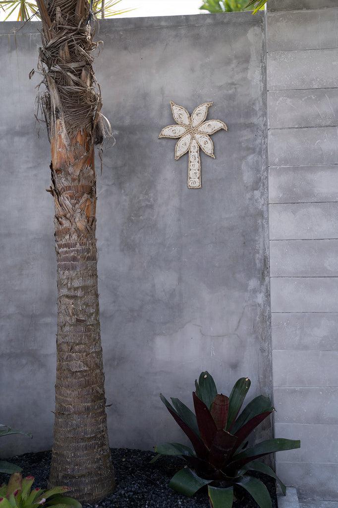 De Schelp Palmboom - Wit Bazar Bizar Breng de tropen naar je huis met dit leuke hangende deco stuk in de vorm van een palmboom! Het is volledig gemaakt van schelpen en is een unieke toevoeging aan je woonkamer, badkamer of zelfs buitenruimte. Elk stuk is