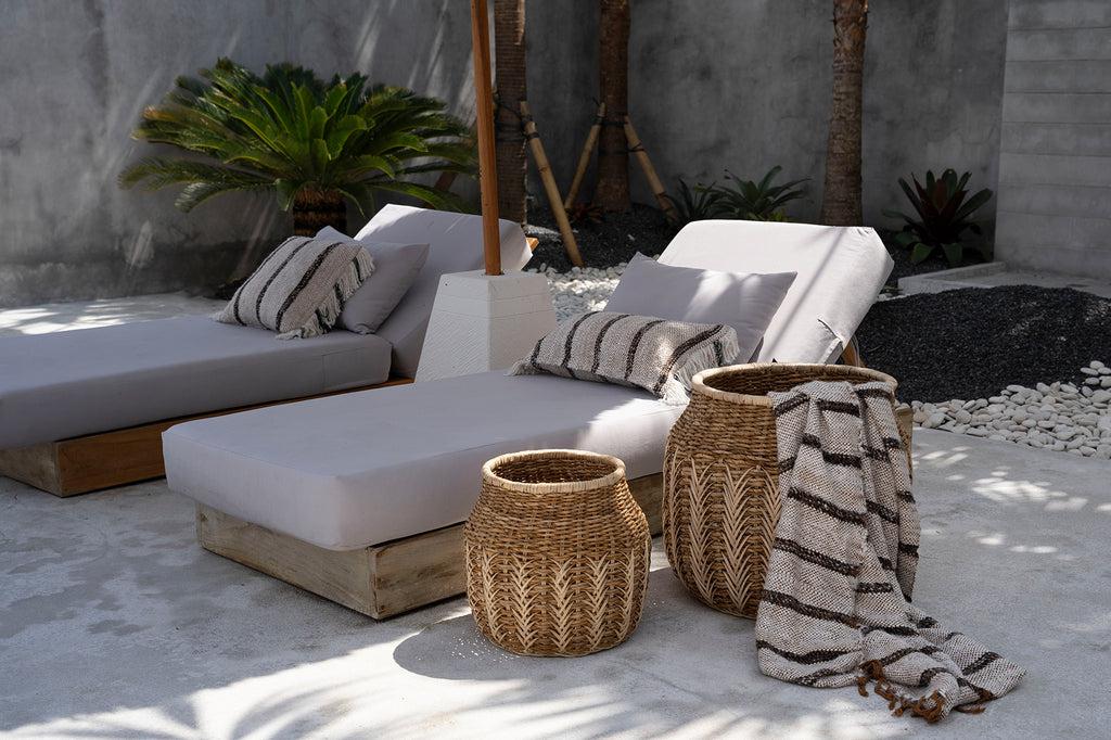 Bohemian buitenruimte met loungebanken en kussenhoesjes in boho-stijl, perfect voor een ontspannen terras of tuin in de zon.